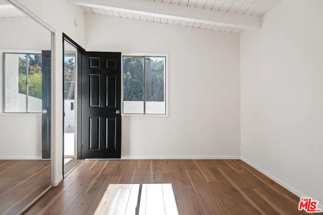 a view of a room with wooden floor and a bathroom