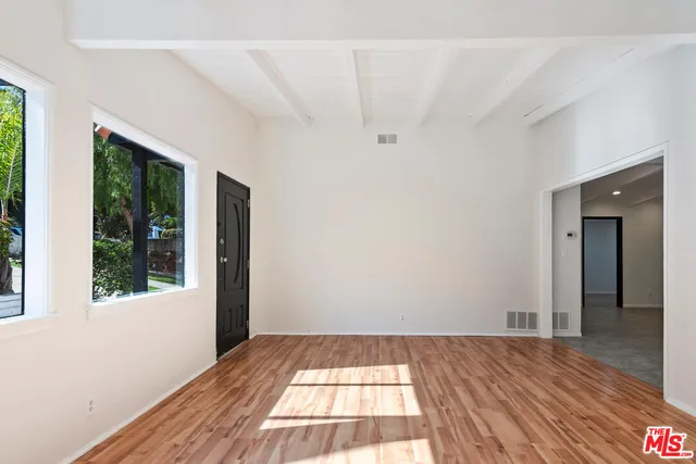 a view of a room with wooden floor and window