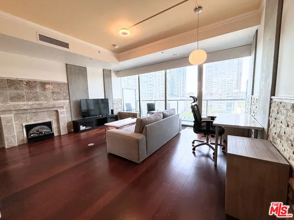 a living room with fireplace furniture and a large window