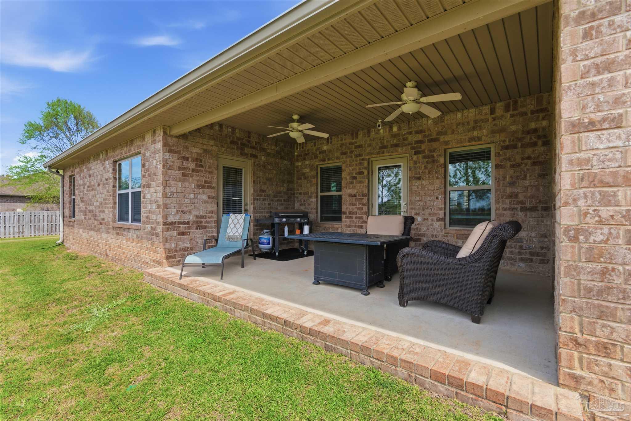 2677 Tulip Hill Road Pace, FL 32571 - Photo 34 of 35 a patio with couches table and chairs and potted plants