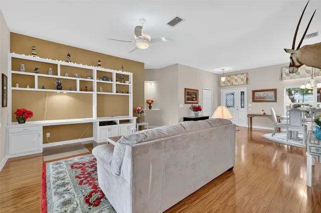 a kitchen with stainless steel appliances granite countertop a refrigerator a sink dishwasher a stove and white cabinets with wooden floor