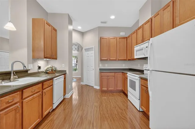 a large kitchen with cabinets wooden floor and stainless steel appliances