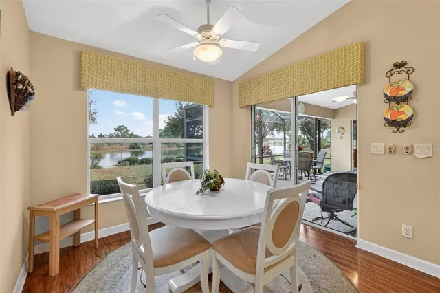 a view of a dining room with furniture a kitchen and chandelier