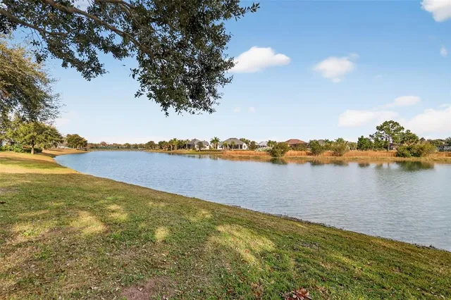 an aerial view of residential houses with outdoor space and lake view