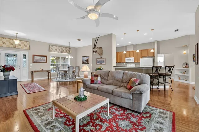 a living room with furniture large window and wooden floor