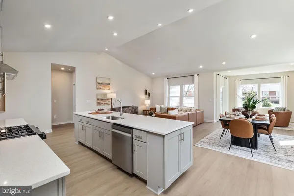 a large kitchen with kitchen island a sink table and chairs