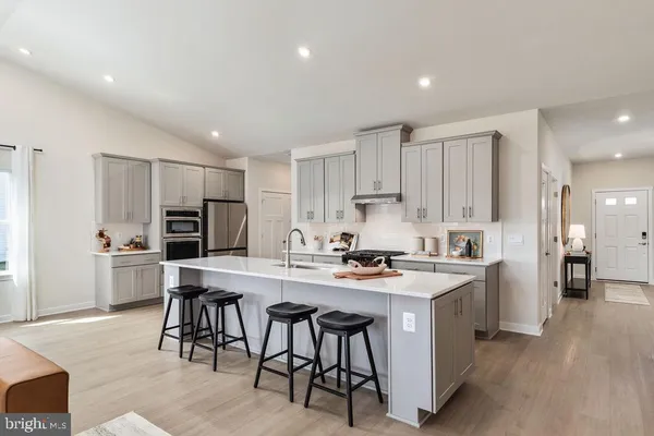 a kitchen with stainless steel appliances a stove a sink a refrigerator and cabinets