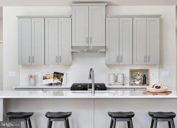 a kitchen with stainless steel appliances granite countertop white cabinets a sink and a stove