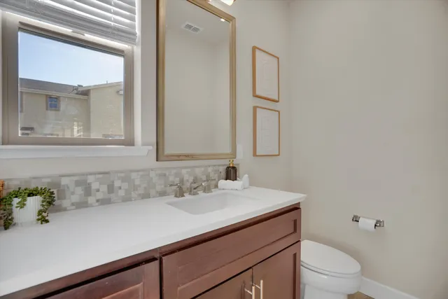 a bathroom with a sink vanity granite and toilet