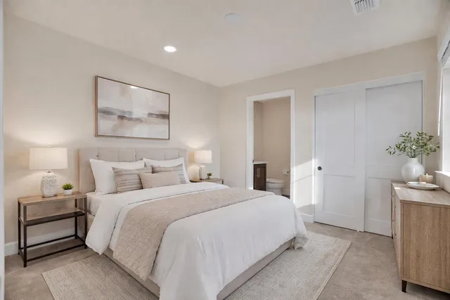 a bedroom with a bed and a painting on the wall