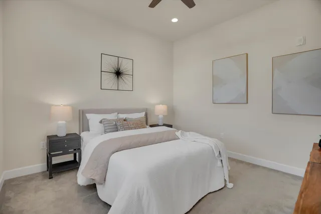 a bedroom with a bed and a lamp on the dresser