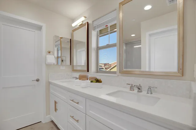 a bathroom with double sink and a mirror
