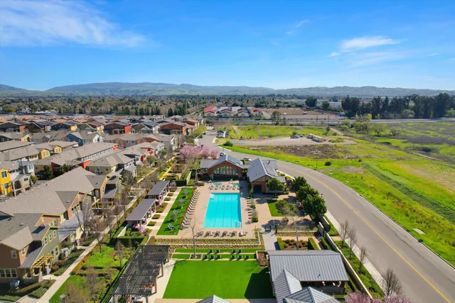 an aerial view of a city with lots of residential buildings and mountain view in back