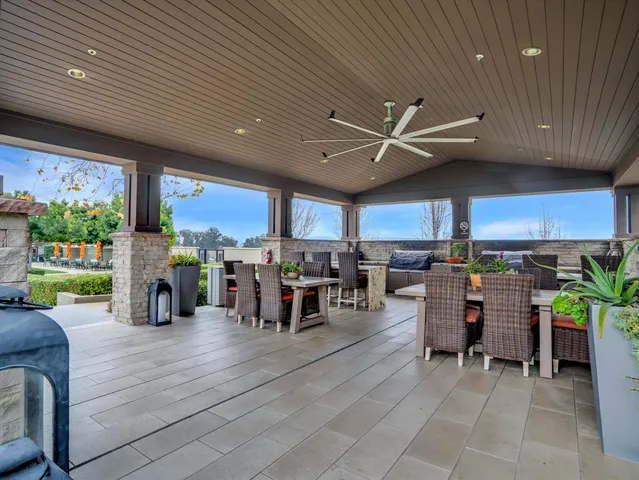 a living room filled with lots of furniture a chandelier and a dining table