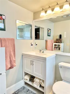 a bathroom with a sink mirror vanity and toilet