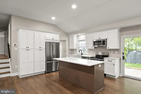 a kitchen with stainless steel appliances granite countertop a refrigerator stove and sink