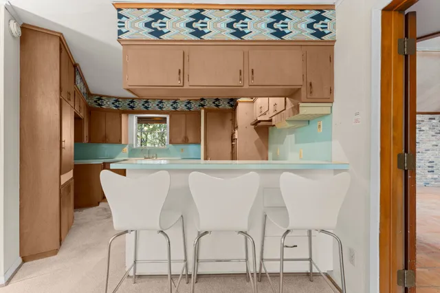 a dining table chair in a kitchen next to a window