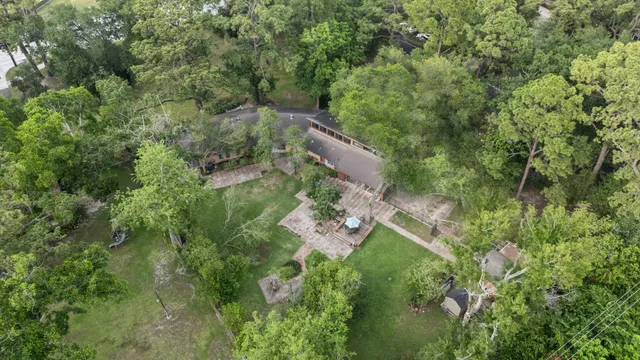 an aerial view of residential house with outdoor space and trees all around