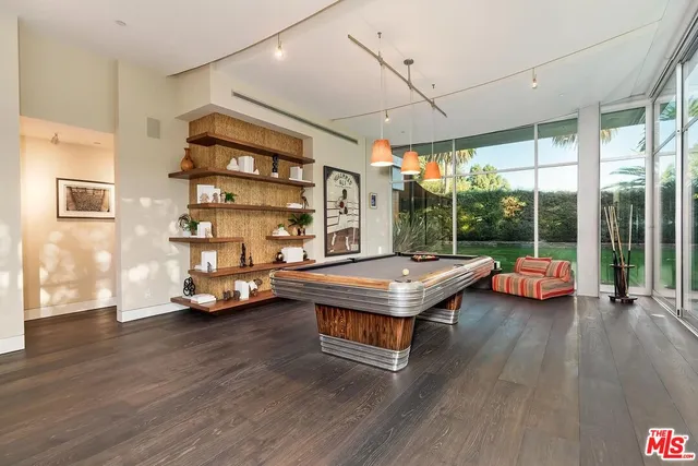 a living room with lots of books and a wooden floor