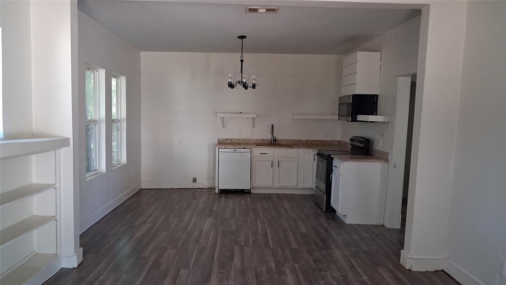1224 Frost Avenue Waco, TX 76708 - Photo 10 of 12 Wood-finish flooring, white cabinetry, light-toned countertops, built-in shelving, and a modern chandelier