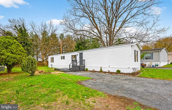 a view of a house with backyard and a tree