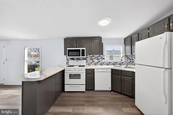 a kitchen with a sink a refrigerator and white cabinets