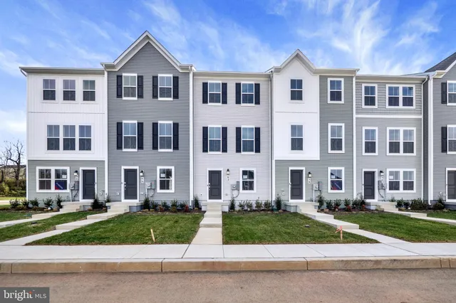 a front view of a residential apartment building with a yard