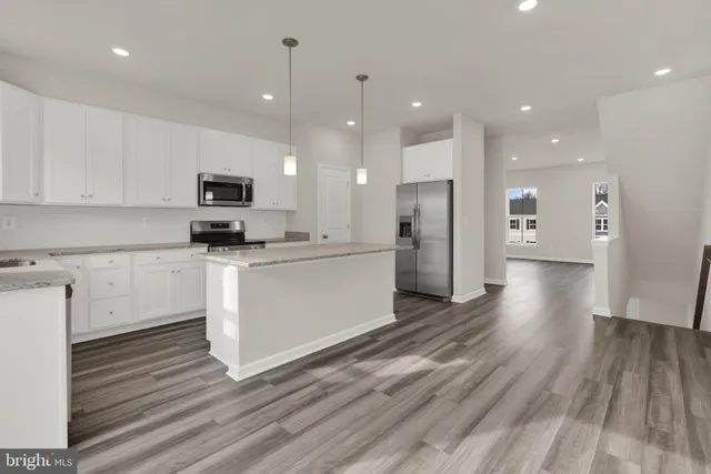 a kitchen with a refrigerator a stove top oven a sink and cabinets