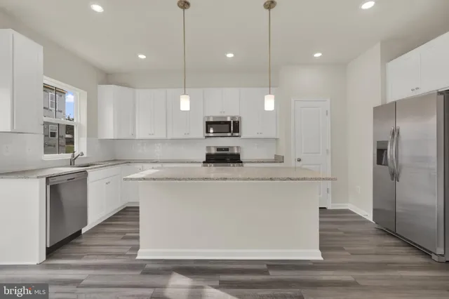 a large kitchen with cabinets appliances and wooden floor