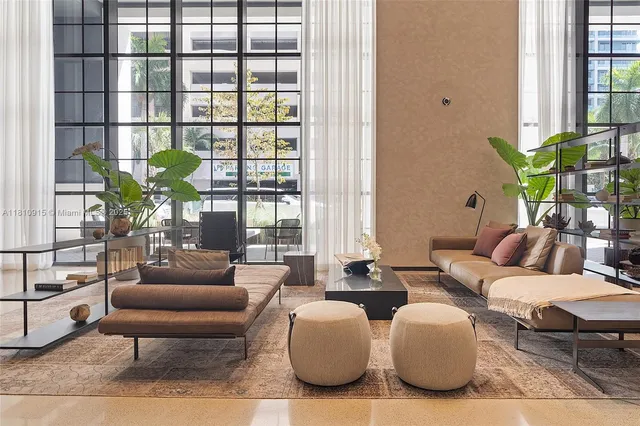 a living room with furniture and potted plants