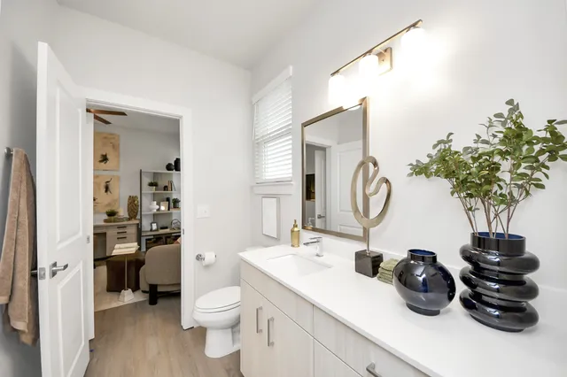 a living room with furniture kitchen view and a wooden floor