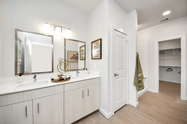 a bathroom with a sink and mirror with shower