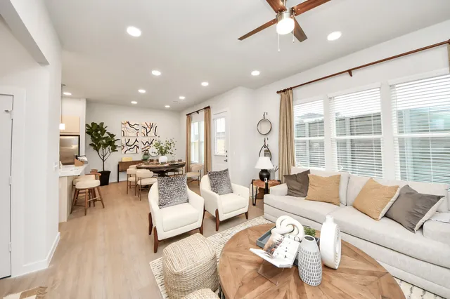 a kitchen with stainless steel appliances a refrigerator a stove a sink a dining table and chairs