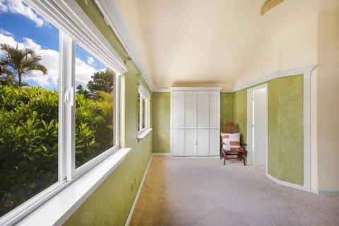 a spacious bedroom with a large window and a balcony