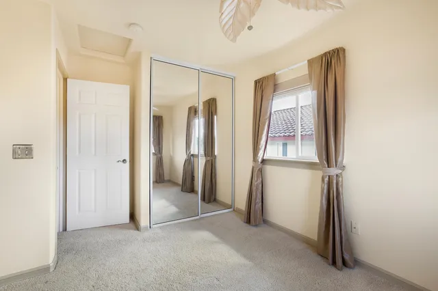 an empty room with a window and ceiling fan