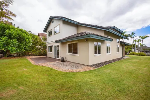 a view of a house with a yard and large tree