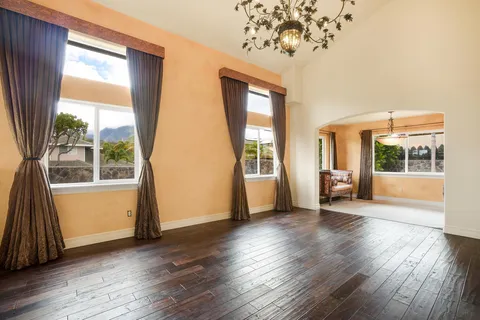 a view of a big room with wooden floor and windows