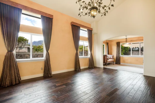 a view of a big room with wooden floor and windows