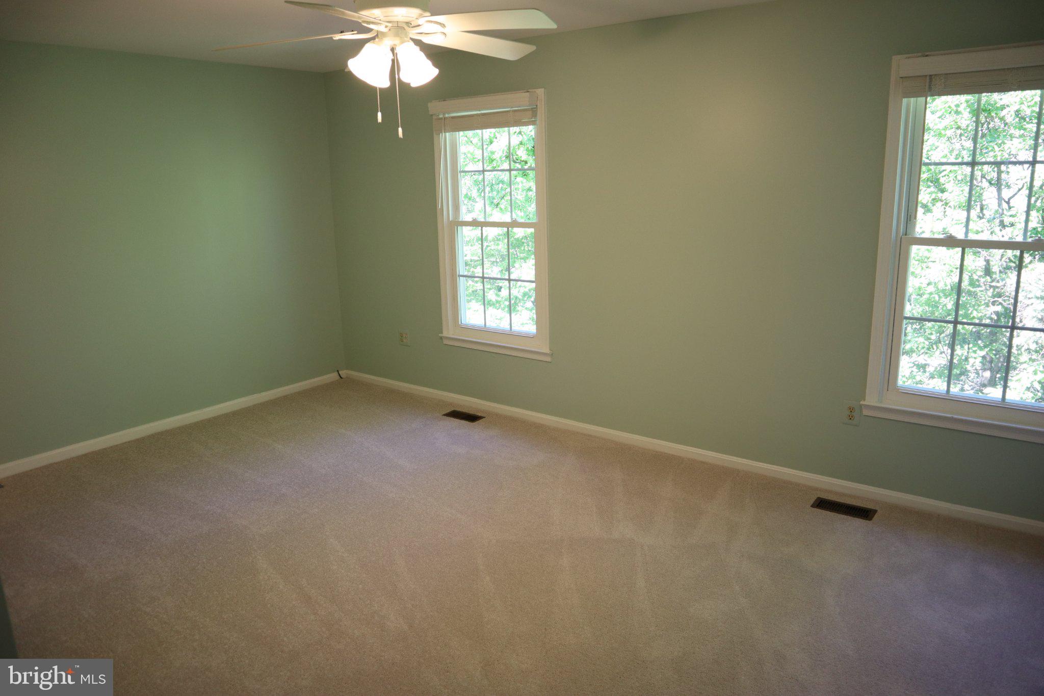 10848 Douglas Avenue Silver Spring, MD 20902 - Photo 16 of 33 an empty room with a chandelier fan and windows