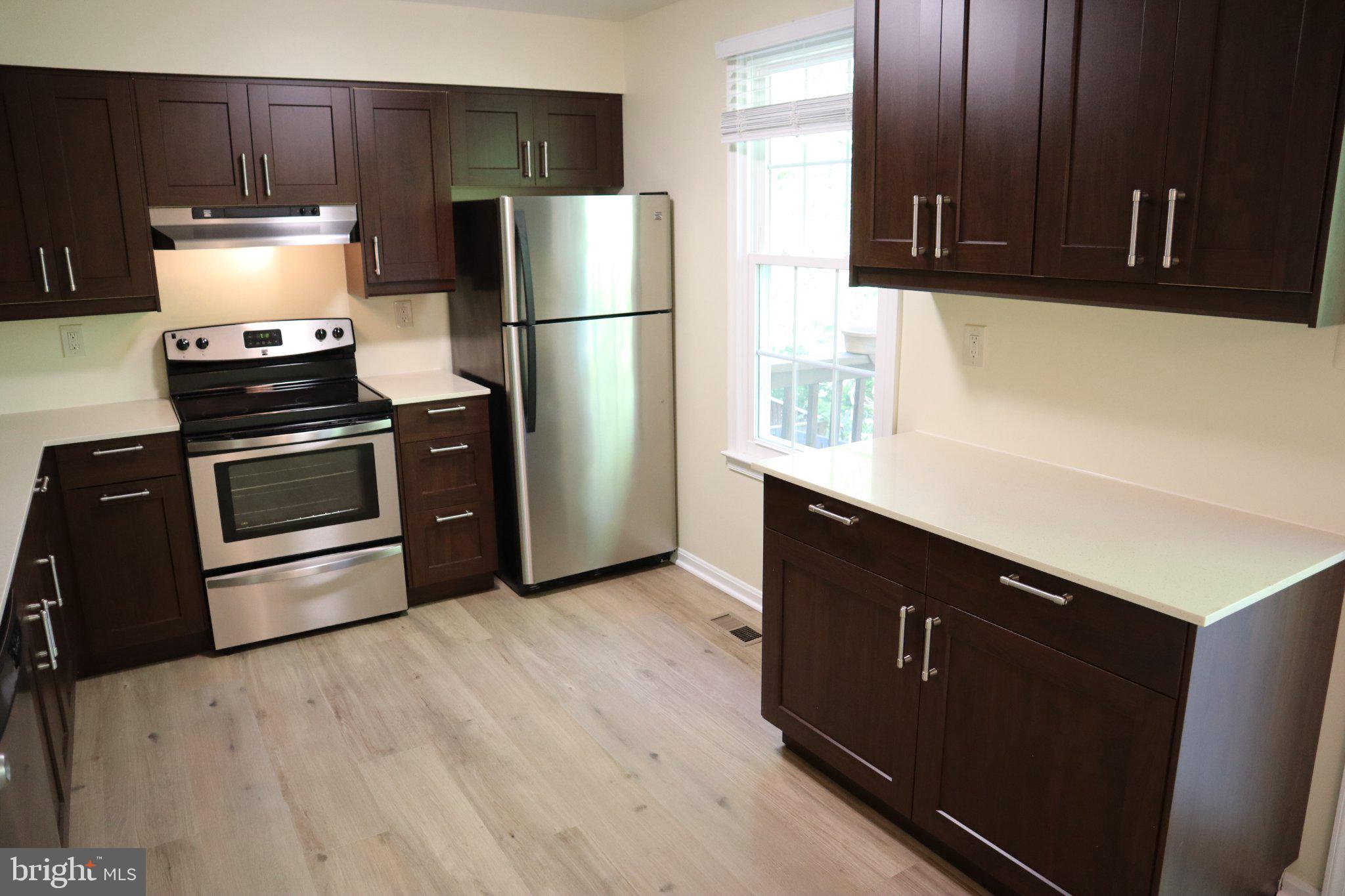 10848 Douglas Avenue Silver Spring, MD 20902 - Photo 9 of 33 a kitchen with stainless steel appliances a refrigerator a stove a sink and a microwave