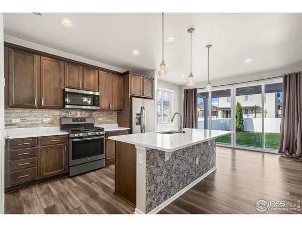 a kitchen with kitchen island a sink stove and wooden floor