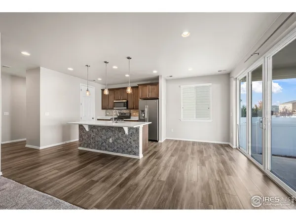 a open kitchen with kitchen island a sink dishwasher stove with wooden floors