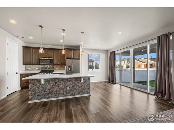 a view of kitchen with refrigerator microwave and wooden floor