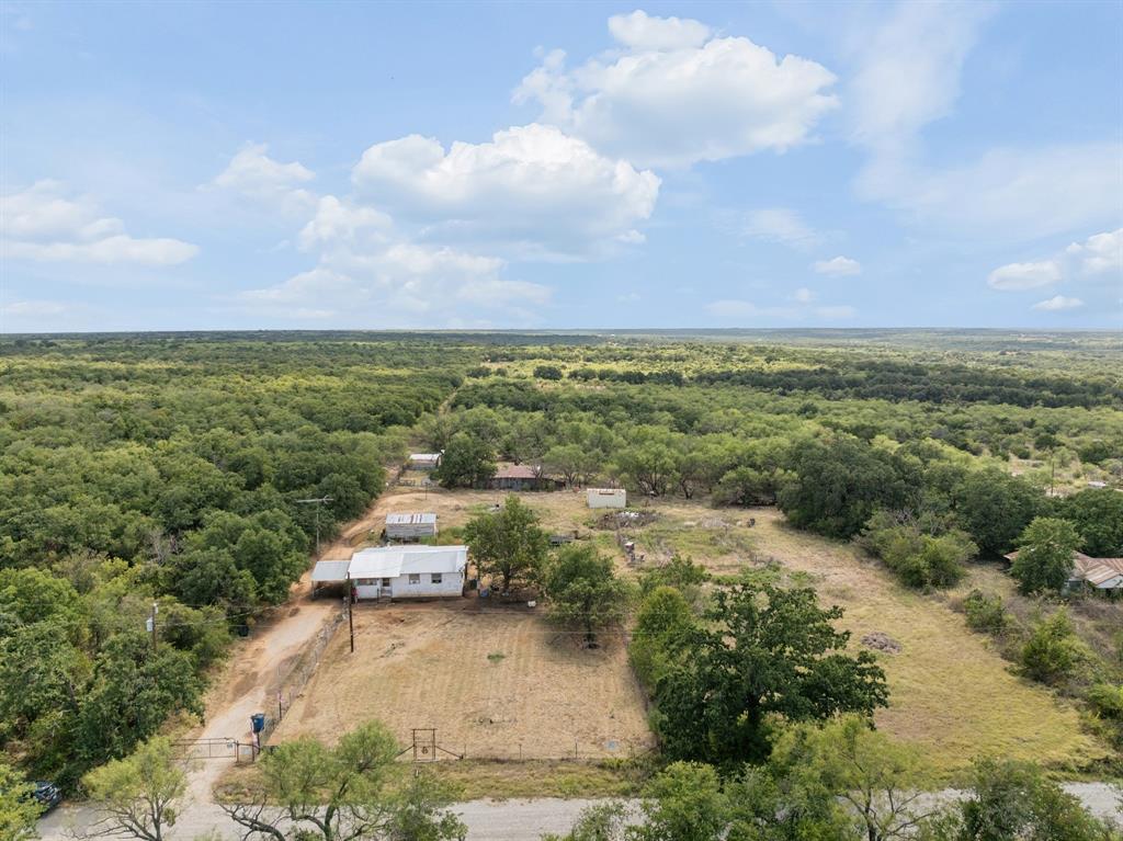 11097 County Road 137 Ranger, TX 76470 - Photo 33 of 40 Expansive property featuring multiple structures, mature trees, and a gravel driveway