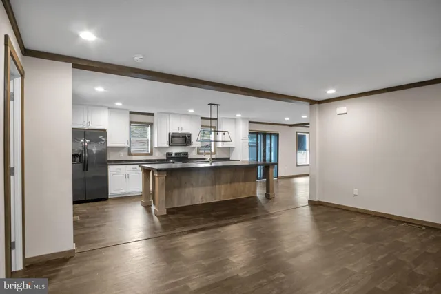a large kitchen with a center island and stainless steel appliances