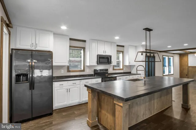 a kitchen with stainless steel appliances granite countertop a refrigerator a sink and a stove