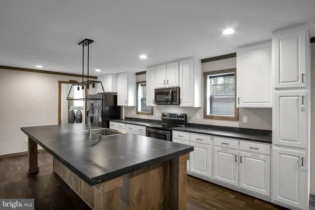a kitchen with stainless steel appliances granite countertop a sink a stove and center island