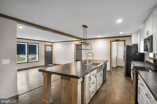 a kitchen with stainless steel appliances granite countertop a sink a refrigerator and a stove