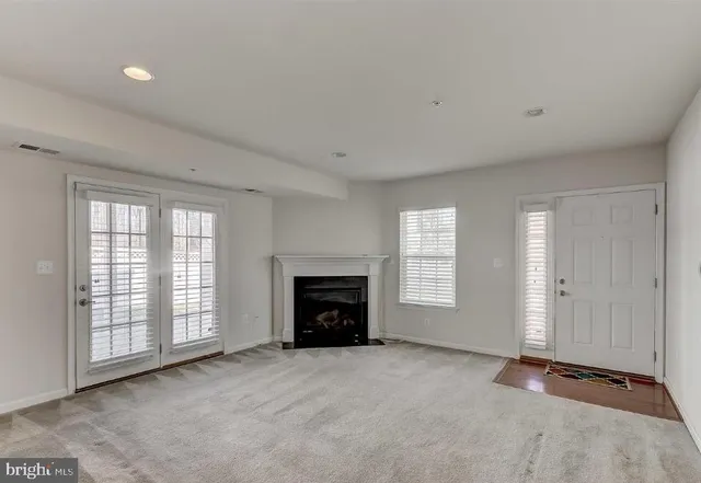 a view of an empty room with a window and fireplace