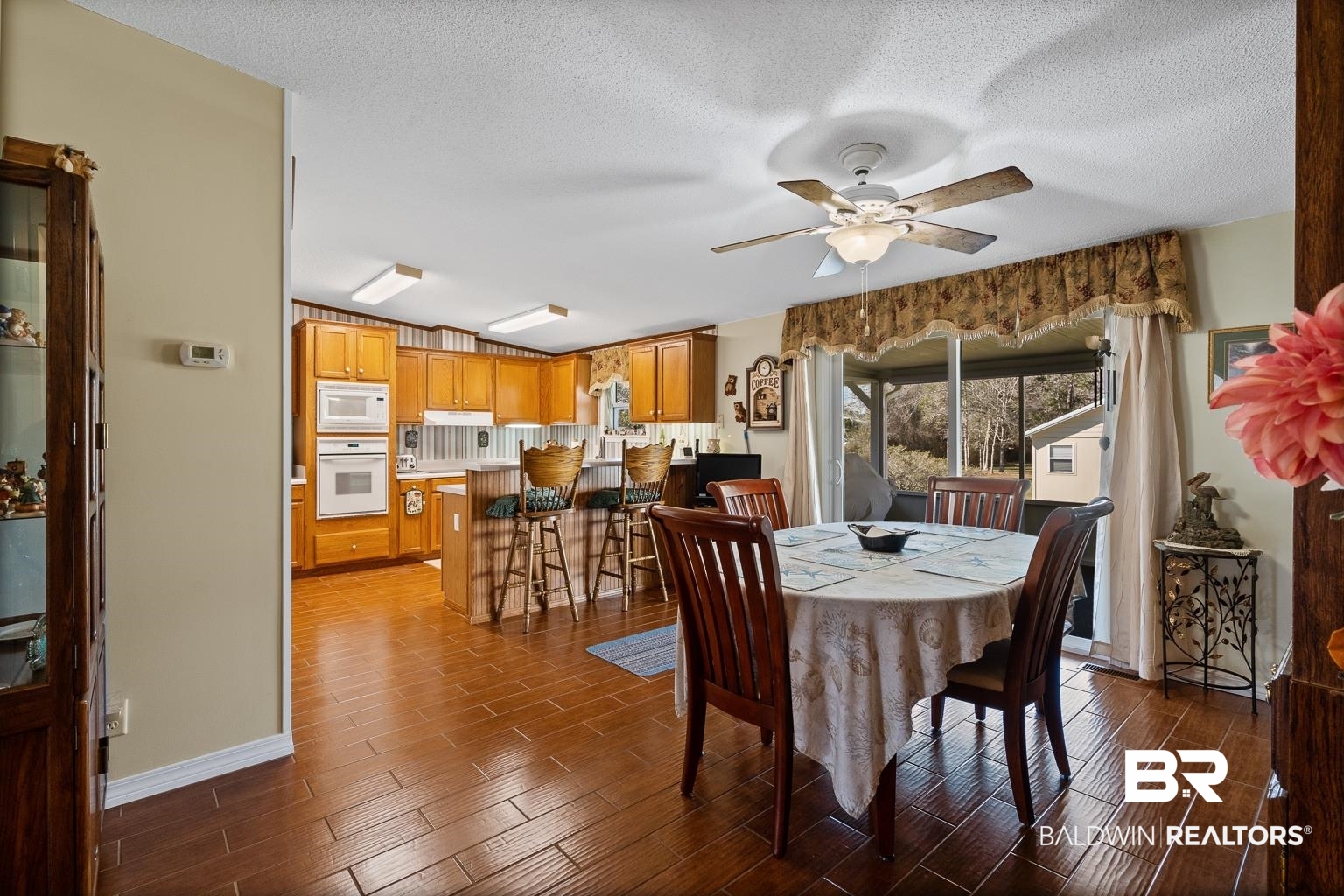 10647 Rte Road Lillian, AL 36549 - Photo 34 of 62 Dining area featuring wood finish floors, ceiling fan, a textured ceiling, and baseboards